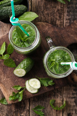 Fresh green smoothie with straws on a wooden table,healthy vegan food