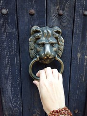 Decorative lion head door knob on a vintage wooden door