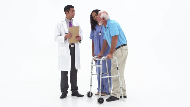 Doctor and nurse talk to elderly patient on walker and passing over medications