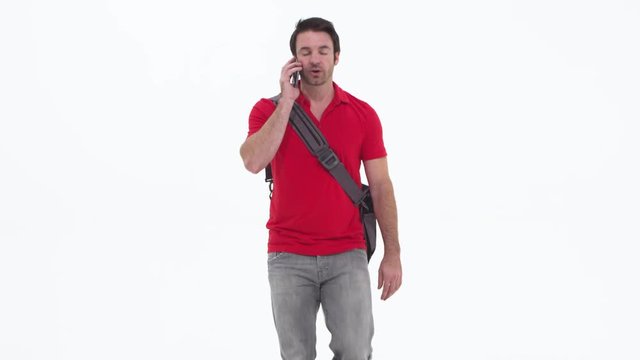 Young caucasian man talking on cellphone and walking