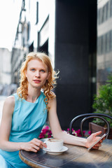 young female in blue dress at cafe on street