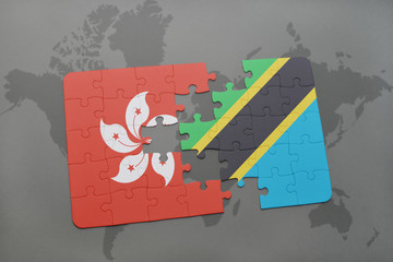 puzzle with the national flag of hong kong and tanzania on a world map background.
