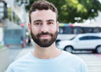 Mann mit Bart in der Stadt lächelt