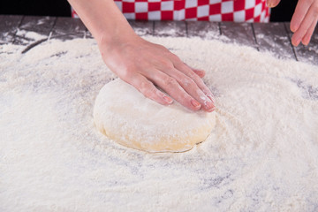 Cook preparing dough for baking in the kitchen