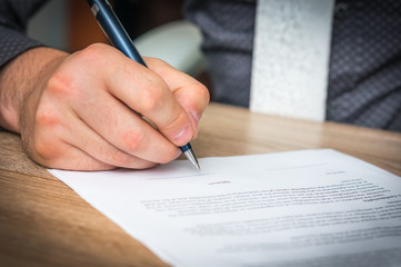 Businessman is signing a contract to conclude a deal
