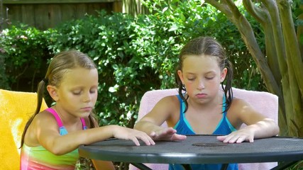 Two cute little girls who are done playing in the water wait patiently for a cool creamy summertime ice cream treat. 4K 
