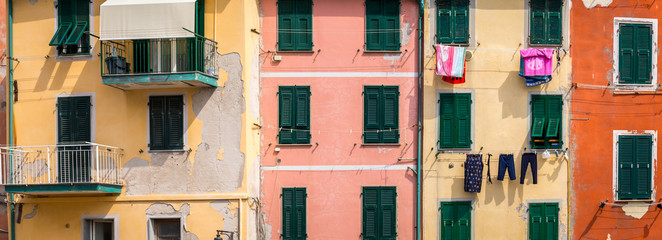 panorama sur les façades colorés d'un village italien avec du linge pendu aux fenêtres