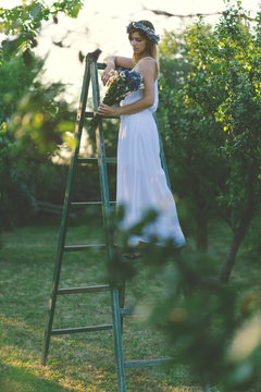 Young woman holding bouquet of wild flowers.