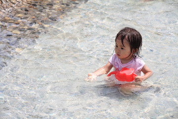 ジョーロで水遊びする幼児(1歳児)