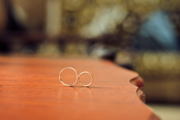 Wedding rings on wooden table.