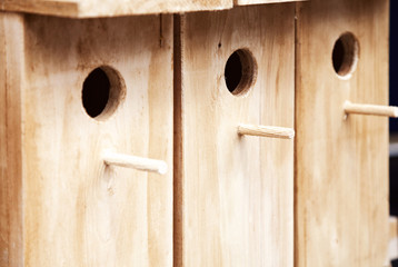 Several wooden birdhouses in a row background. A few wood bird houses for sale backdrop