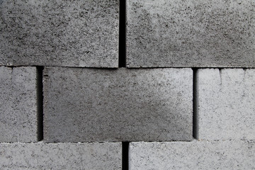 Gray building cinder blocks made of cement stacked close-up background. Lot of large concrete bricks stacking texture