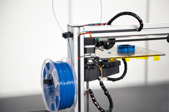 3d printer with blue filament coil close-up. 3d printing process technology
