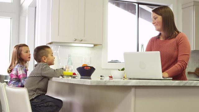 Mom talking to daughter and son in the kitchen