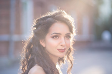 Portrait of young beautiful woman twenty five years old with dark brown or black hair outdoors on sunset. Lifestyle concept