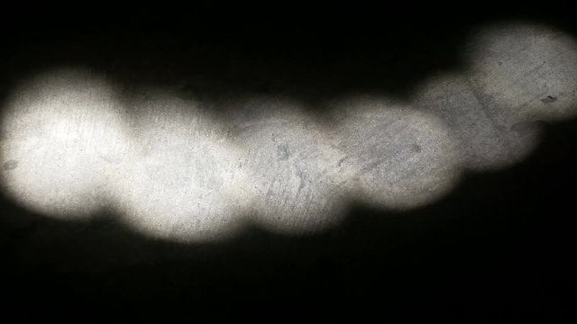 A mysterious strobe of light on a bare concrete floor.