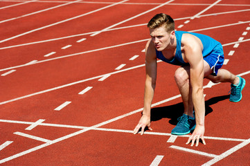 Young athlete on starting blocks.