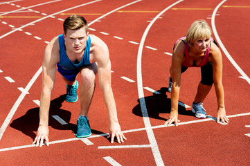Sprinters ready for race on racetrack.
