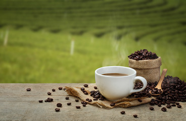 Hot Coffee cup with Coffee beans on the wooden table and the pla