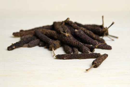 Long pepper or Pipli or Dipli (Piper longum) isolated on wood ba