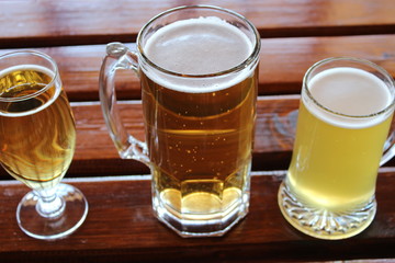 A selection of lager, cider and wheat beer on a wooden table in a craft brewery