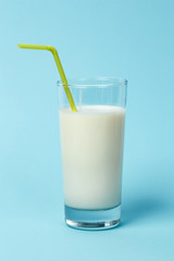 Fresh glass of milk with Straw, on blue background