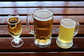 A selection of lager, cider and wheat beer on a wooden table in a craft brewery
