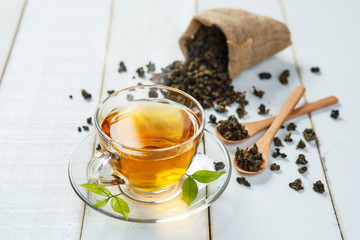 Cup of tea and leaves tea on white wooden table