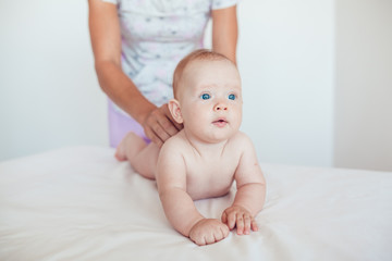 Woman doing exercises and massage the baby