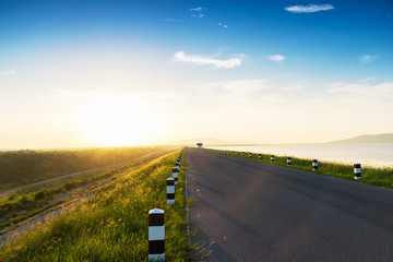 Landscaped walkway around a meadow at sunset sky change from blue to orange,Walkway with stunning views for jogging.