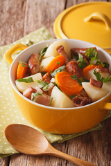 Portion of the Dublin coddle close-up in a yellow pot. Vertical
