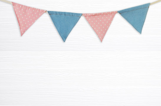 Colorful party flags hanging on blank white wood background