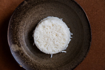 Rice on terracotta brown; organic healthy food cuisine