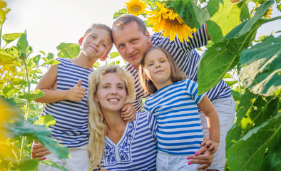 Happy family with two children in sunflowers