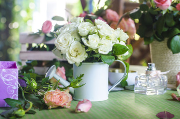 Bouquet of roses in a vase on a wooden table.