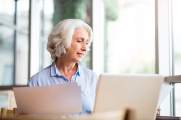 Pleasant content aged woman sitting in the cafe