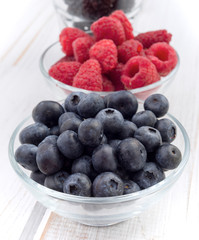 two bowls with blueberries and raspberries