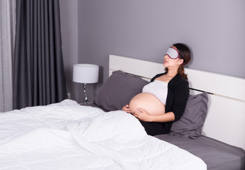 pregnant woman sleeping on bed in the bedroom