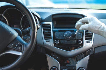 Man wearing gloves to clean the dashboard of the car. Auto Service