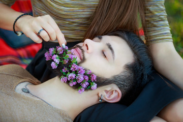 Obraz na płótnie Canvas Girl puts a flower in his beard Man