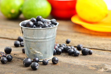 Ripe blueberries in a cup on rustic wooden table