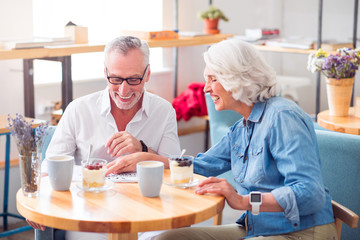 Positive senior couple reading newspaper