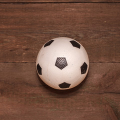 Children rubber soccer ball on a wooden background
