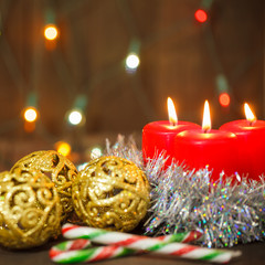 three burning candles and golden balls. Christmas still life