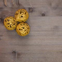 openwork gold Christmas balls on a wooden background