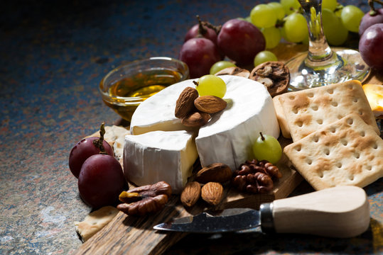 snacks and camembert cheese on a dark background, closeup
