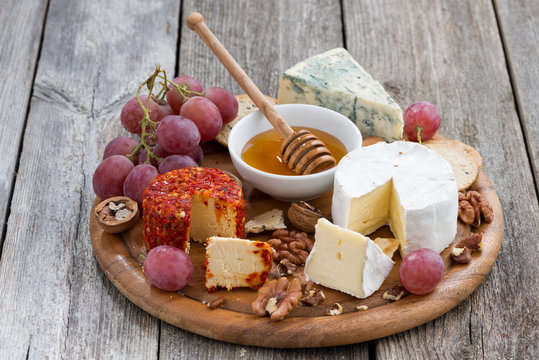 soft cheeses and snacks on a wooden background