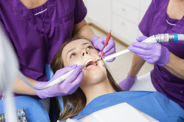Midsection Of Mature Dentists Working On Young Female Patient's 