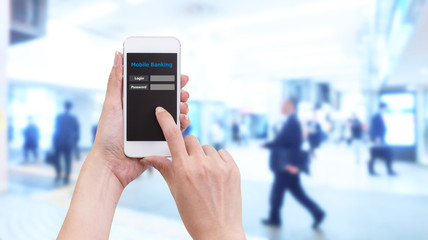 Hand holding smartphone with Mobile Banking login screen on blur