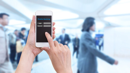 Hand holding smartphone with Mobile Banking login screen on blur